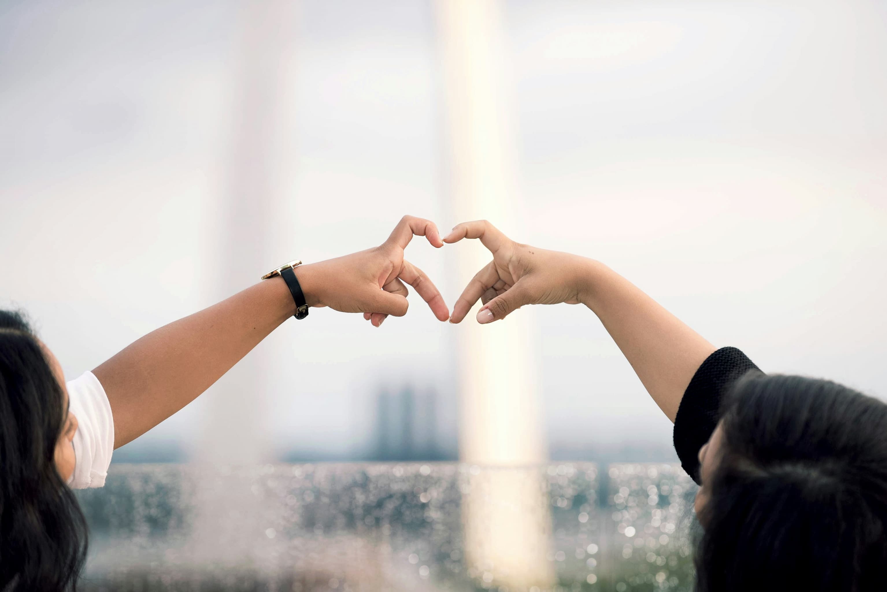 Photo of two people holding their hands to form a heart